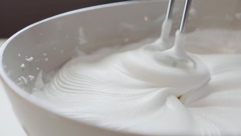 Whisking cream with the electric whisk mixer. Whipped cream. The cream reaches stiff peaks. Closeup shot video