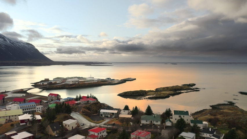 Aerial drone flight over Reykjavik, Iceland, 4k. Beautiful north city with small houses near sea at sunset with view at snowy volcano, fantastic panorama view, little islands with houses. Royalty-Free Stock Footage #1055946782