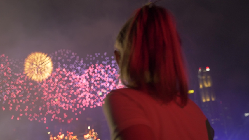Slow motion of the silhouettes of young women watching fireworks on the holiday. Hands in the air, pretty girl having fun and dancing. Entertainment industry, recreation concept. Royalty-Free Stock Footage #1055957117