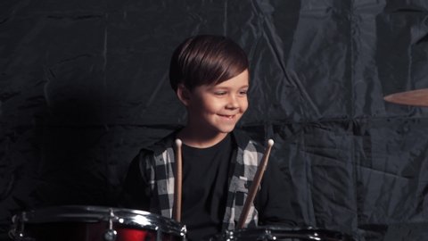 Satisfied boy playing a drum kit. Rehearsal before the concert.