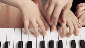 Close up of girls hands on piano keys. girls learning to play the synthesizer.