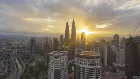 Time lapse: Aerial Malaysia cityscape view during dusk overlooking a skyline and construction area at sunset in Malaysia. Day to night. Zoom in motion timelapse. Prores Full HD