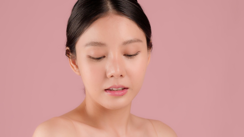 Close up Slow motion Beauty shot of Beautiful Asian girl looking at camera isolated on pink background Royalty-Free Stock Footage #1055969117