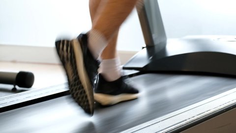 leg of man running on treadmill in the gym which runner athletic by running shoes. Health and sport concept background,  Healthy lifestyles