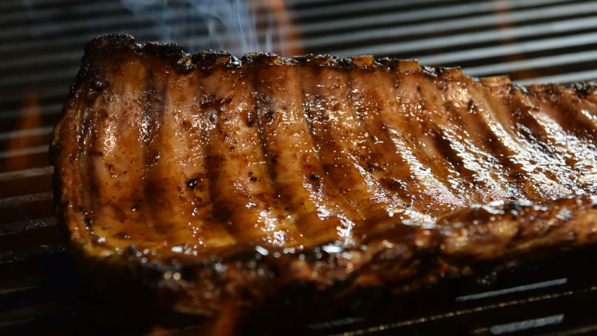 Grilled pork ribs on the flaming grill . Royalty-Free Stock Footage #1055972294