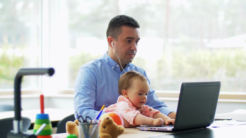 remote job, multi-tasking and family concept - middle-aged father with baby working on laptop at home office Royalty-Free Stock Footage #1055973965