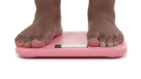 close-up portrait of black plus size woman's legs, demonstrating weigh-out process isolated on white background