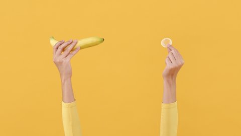 Woman hands showing banana and condom for safe sex and contraceptive concepts