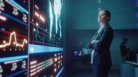 Young Female Computer Science Engineer Looking at Big Screen Display Showing Global Map with Data Points. Telecommunications Technology Company System Control and Monitoring Room with Servers. - Powered by Shutterstock - Get 15% off with code: PIKWIZARD15