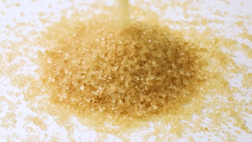 Making a heap of natural brown cane sugar on white background | Shutterstock HD Video #1055988767
