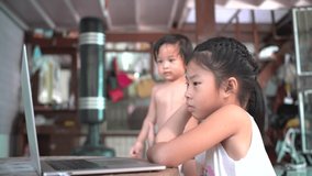 Little asian girl use laptop computer study from home with technology