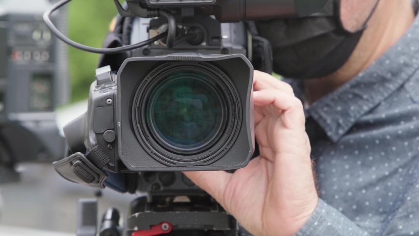 Close-up of a television camera lens. cameraman operator works with a large professional video camera. a journalist filming a news report. Kyiv, Ukraine, July 14, 2020 | Shutterstock HD Video #1055997470