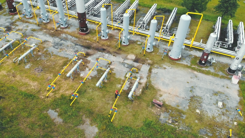Aerial view Gas production. Large gas distribution complex. A gas worker or a station operator shuts off the gas supply. Production station located in the mountains. Royalty-Free Stock Footage #1056000107