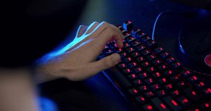 Close-up on the Hands of the Gamer Playing in the Video Game Using keyboard Background with Cool Neon Lights. 