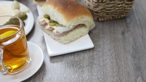Tasty morning breakfast with bread meat sandwich and tea cup on wooden table background.