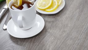 Homemade morning breakfast with tea cup and lemon slices on wooden table background.