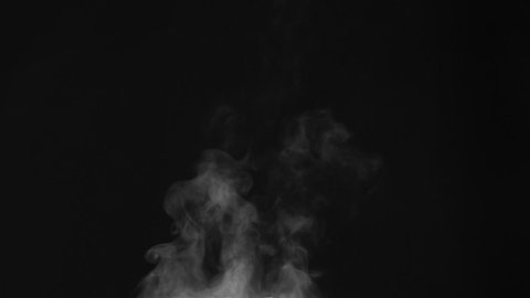 Hot Vapor Stream Tends Up. White Steam rises from a large pot that is behind the scenes. Black background. Filmed at a speed of 240fps