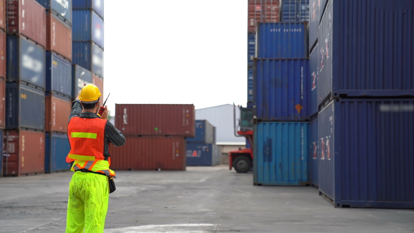 Engineer control loading Container from Cargo freight ship for import and export , support logistics transportation concept. Royalty-Free Stock Footage #1056009371