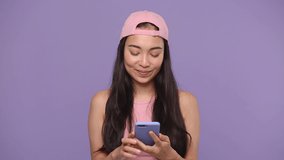 Young asian woman 20s in pink clothes using mobile cell phone doing selfie videoconference conducting pleasant conversation isolated on pastel purple violet background studio. People lifestyle concept