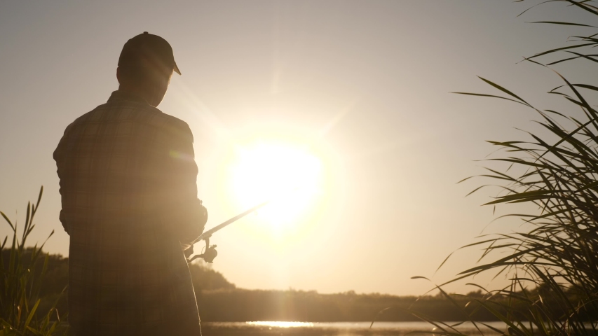 fisherman fishing fish silhouette on sunset. man recreation with fishing rod outdoor catching fish at sunrise. hobbies lifestyle fishing sport concept sunset. man relaxes with fishing rod Royalty-Free Stock Footage #1056011291