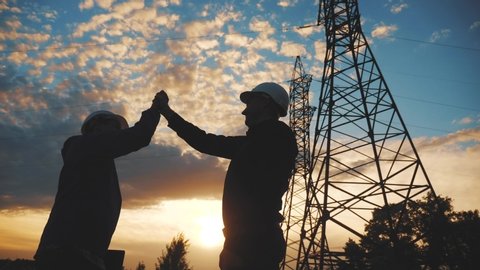 teamwork. two electricians engineer shake hands. business teamwork partnership energy technology industry a concept. silhouette two lifestyle workers handshake. teamwork in energy 