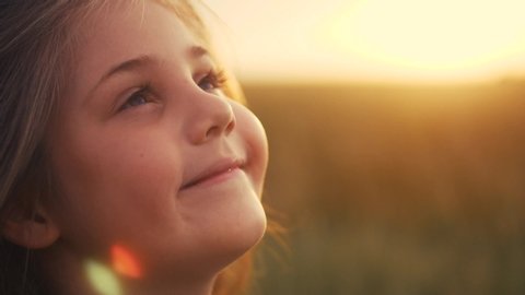 happy little girl child looking up eyes dream. kid wants a dream come true portrait at sunset. baby daughter look up silhouette dreaming of a happy childhood. kid free face sister side view thinks