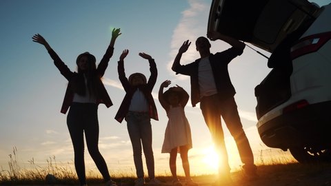 happy family wave goodbye campsite on a car outdoors silhouette at sunset. parents and kid children waving hands at the sunset nature. day off holiday friendly family dream teamwork concept. happy