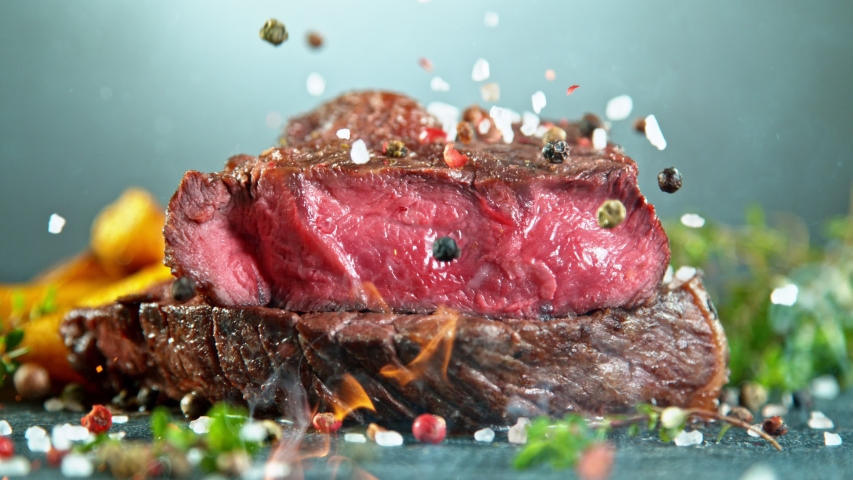 Close-up of falling tasty beef steak, super slow motion, filmed on high speed cinematic camera at 1000 fps. Royalty-Free Stock Footage #1056012062