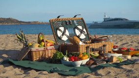 Picnic on the beach. Fruit table. Wicker picnic basket with cheese and wine on a green tablecloth. Wine and cheese. Watermelon, melon, grapes, bananas, pineapple, lemon, apple. Family dinner. Sausage - Powered by Shutterstock - Get 15% off with code: PIKWIZARD15