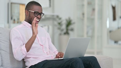 Attractive African Man doing Video Call on Laptop at Home 