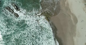 Drone aerial top view of ocean waves breaking on a beach. Sea waves and beautiful sand beach aerial view drone shot. From Playa Carmen, Malpais, Costa Rica.