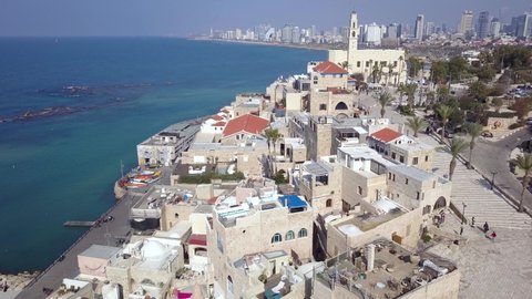 Tel Aviv and Jaffa skyline, aerial view above the old city and port of Jaffa and TLV coastline in the background. Clock Tower in Jaffa - Tel Aviv, Israel.