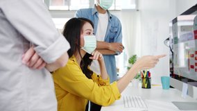 Asia businesspeople using computer presentation meeting brainstorming ideas about new project colleagues and wear protective face mask back in new normal office. Lifestyle and work after coronavirus. - Powered by Shutterstock - Get 15% off with code: PIKWIZARD15