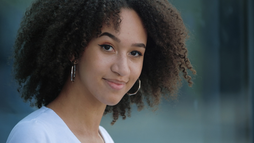 Attractive young afro girl smiles at camera showing hand OK sign. Student shows everything fine success gesture body language. African american millennial curly hair woman smiling, evaluation concept | Shutterstock HD Video #1056041930