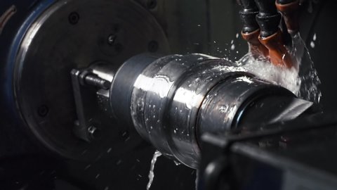 Turning Mill Machine at the Modern Factory, Automated CNC System Spins and Works With Water, Fluids, Splashes, Slow Motion, Close Up