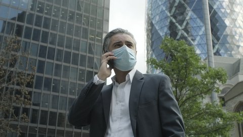 Corporate business man commuting to work wearing face mask in the city of London during Covid-19 Pandemic