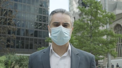 Portrait of Corporate business man wearing face mask in the city of London during Covid-19 Pandemic