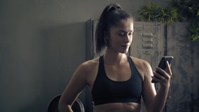 woman using smart phone with personal trainer workout app at home. Woman preparing for workout using fitness app. Close orbit shot.Woman using mobile phone while resting during fitness training 