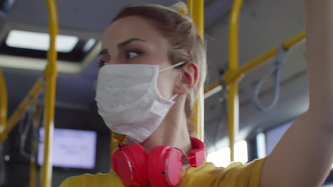 Young woman watching the environment on the bus and wearing a protective mask. Protection concept.