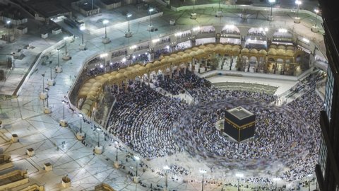 Time lapse sunrise of Muslim pilgrims circling around the holy Kaaba at dawn and praying inside al Masjid al Haram in Mecca, Saudi Arabia. Zoom out motion timelapse. Prores UHD
