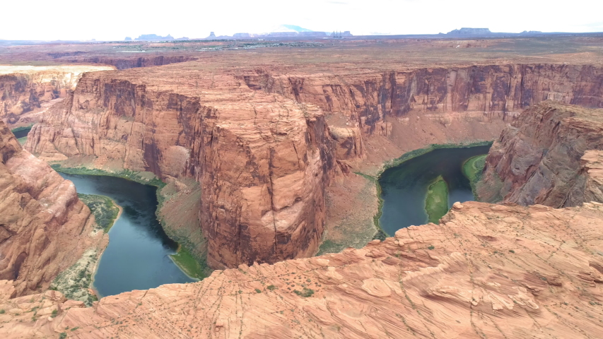 World famous tourists attraction - Horseshoe bend on a cloudy day. Cinematic American Wild West wilderness nature. Aerial red canyon and Colorado river. USA travel and road trip concept footage Royalty-Free Stock Footage #1056068294