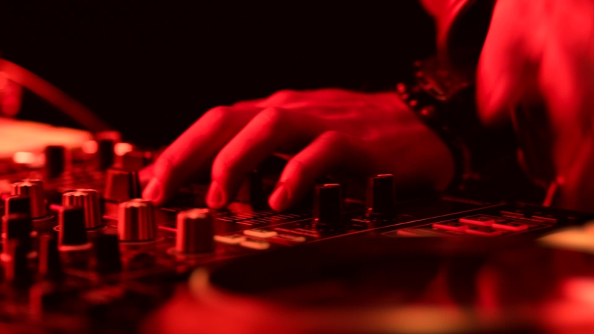 Close-Up of Dj Mixer Controller Desk in Night Club Disco Party. DJ Hands touching Buttons and Sliders Playing Electronic Music . Amazing Close Up of DJ Hands Mixing and Scratching Music on Vinyl Plate Royalty-Free Stock Footage #1056076172