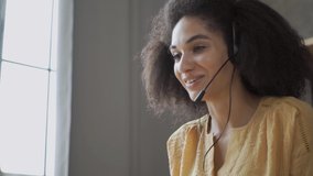 Smiling African American woman with headset using laptop, talking, working customer support service operator at home \office, in headphones with microphone - Powered by Shutterstock - Get 15% off with code: PIKWIZARD15