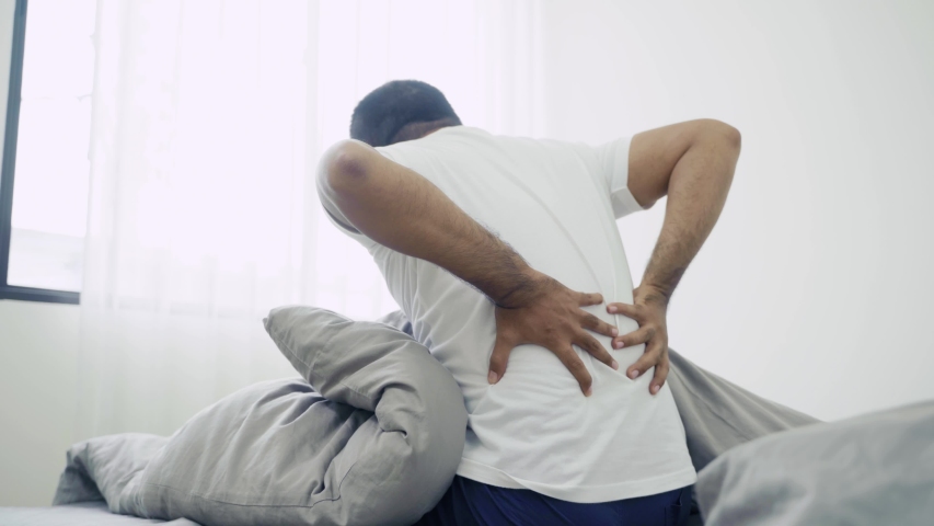 A sick person wake up because he feeling back pain, he try to relax hisself and dissolve his pain by hand on back and neck. 4k Resolution. | Shutterstock HD Video #1056082511