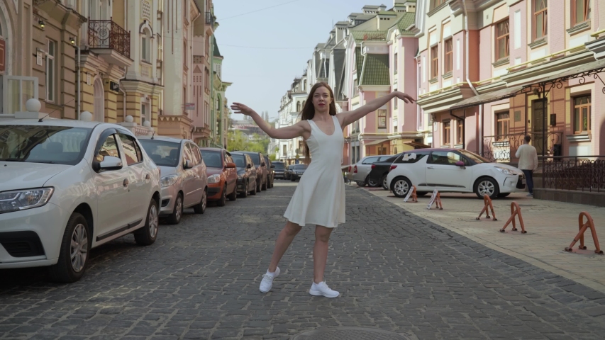 Modern choreography dancer Caucasian girl 25 years old dancing on the street. light woman dancing energetically on the street. sunny summer day. 4K | Shutterstock HD Video #1056084746