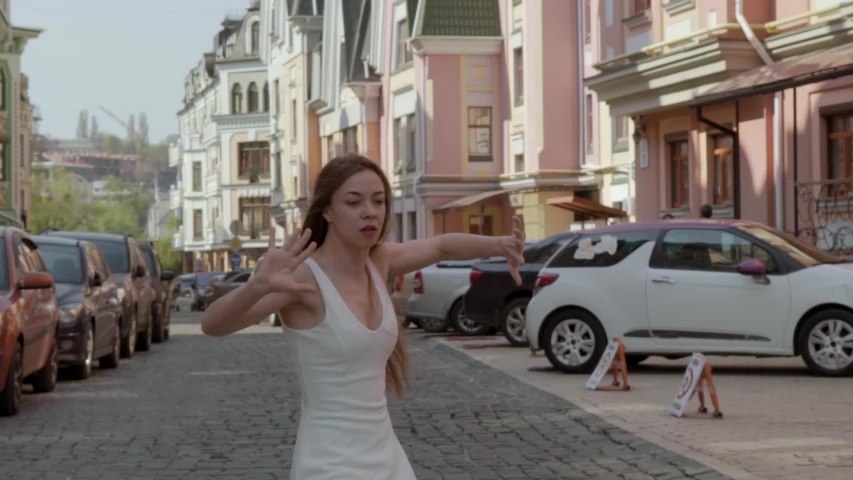Slow motion. middle shot. girl in a white dress dancing in the city. Freedom concept FullHD
