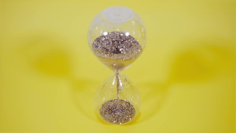 a golden sand clock on the yellow background