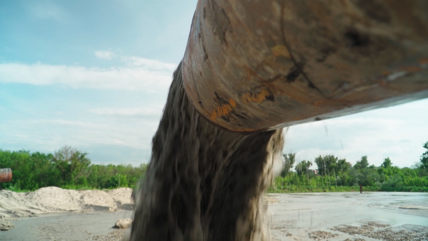 Wastewater from Large Rust Pipe Merge into Environment on the background of the Forest. Sewage from the Sewer Pollutes Terrain. Environmental Pollution. Ecological Catastrophy. Royalty-Free Stock Footage #1056092288