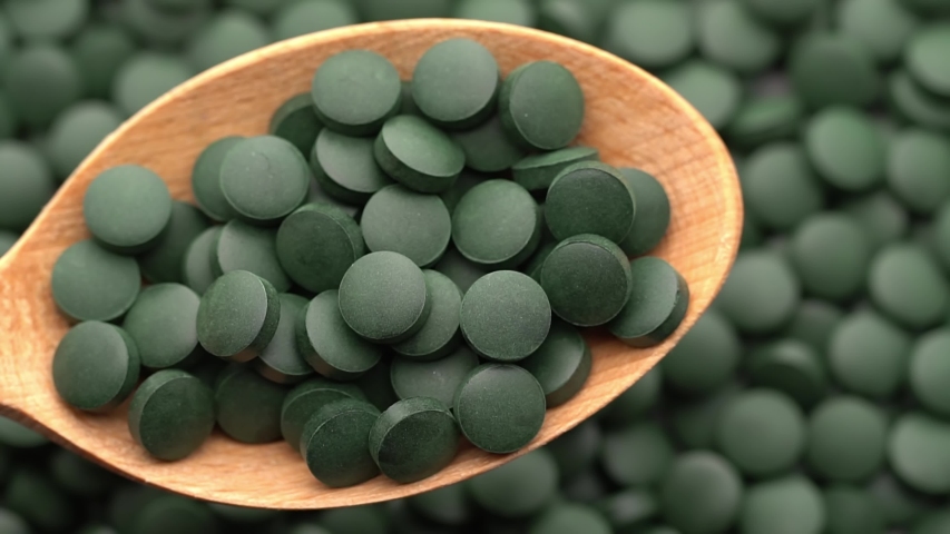rotating Spirulina, chlorella supplement pills close up, in spoon macro shot Royalty-Free Stock Footage #1056095606