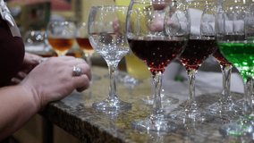 Soft focus video. Bartender pours alcohol drink in wine glasses. Night party, holidays event. Barman working in restaurant. People drinking.